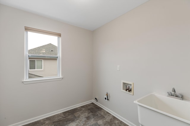 laundry area featuring stone finish floor, hookup for a washing machine, baseboards, a sink, and laundry area