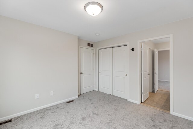 unfurnished bedroom with carpet floors, baseboards, and visible vents