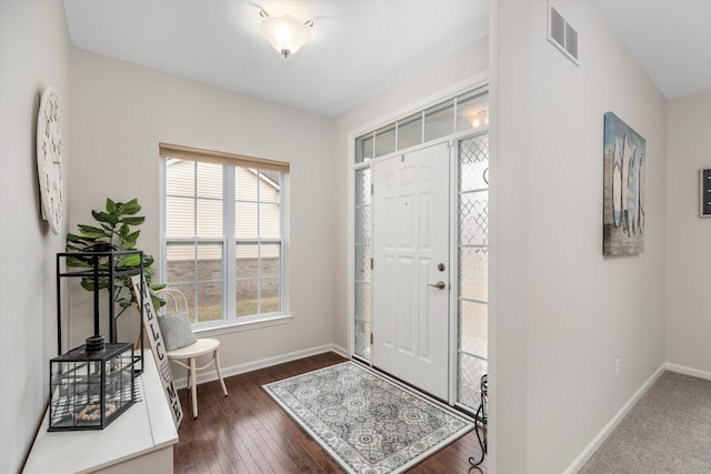 entryway with dark wood-type flooring, baseboards, and visible vents