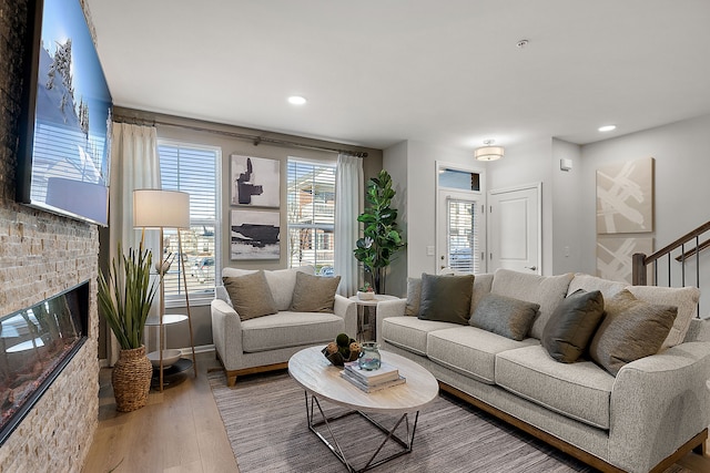 living room featuring recessed lighting, a fireplace, and wood finished floors