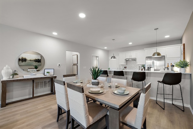 dining room with recessed lighting, baseboards, and light wood-style floors