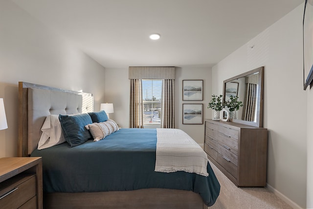 bedroom featuring baseboards and light carpet