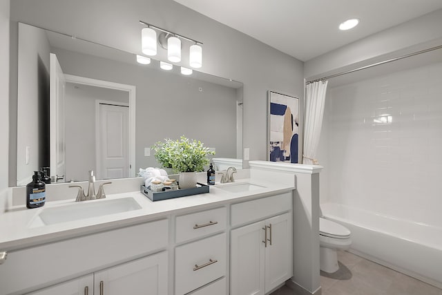 full bathroom with tile patterned floors, toilet, double vanity, and a sink