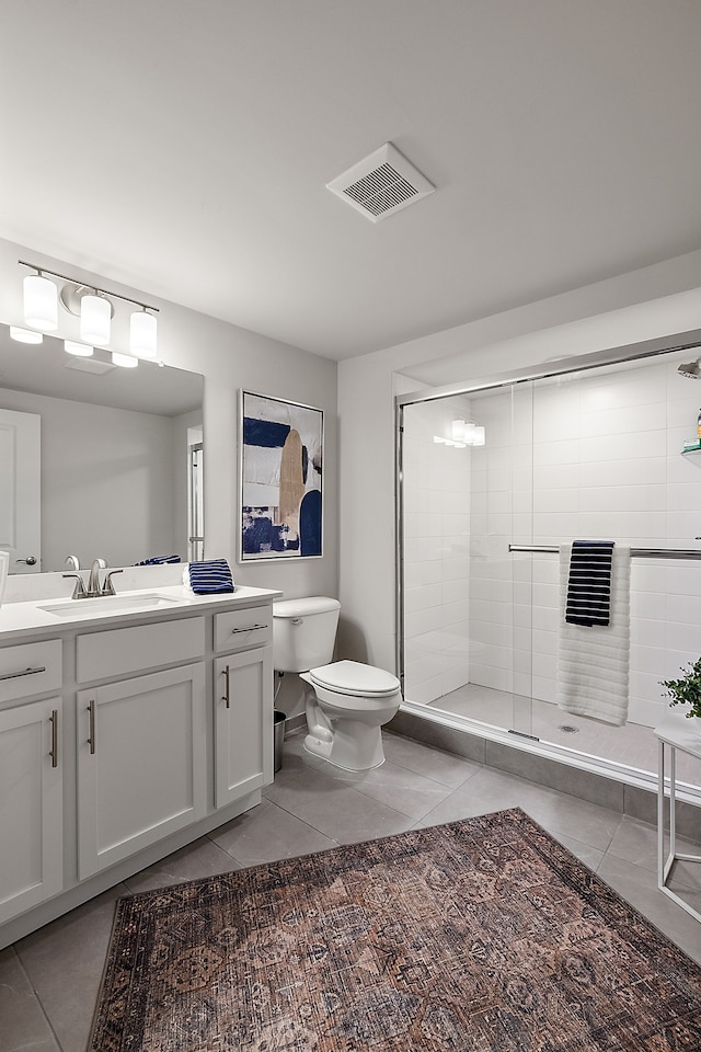 bathroom with tile patterned floors, visible vents, toilet, a stall shower, and vanity