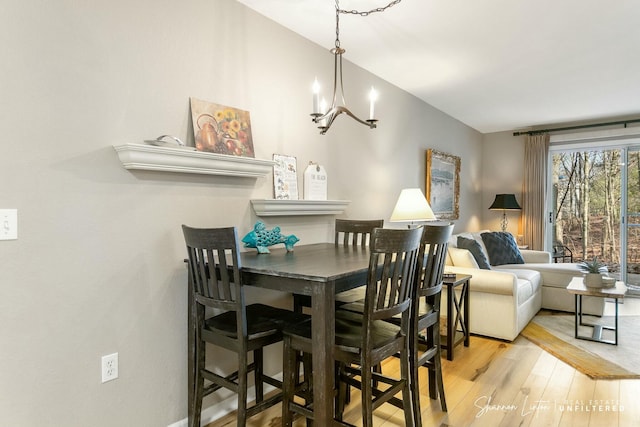 dining room with wood finished floors and a chandelier