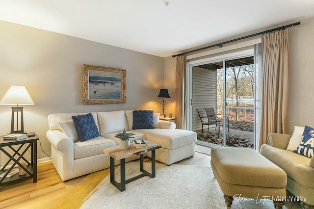 living area featuring baseboards and light wood-style floors