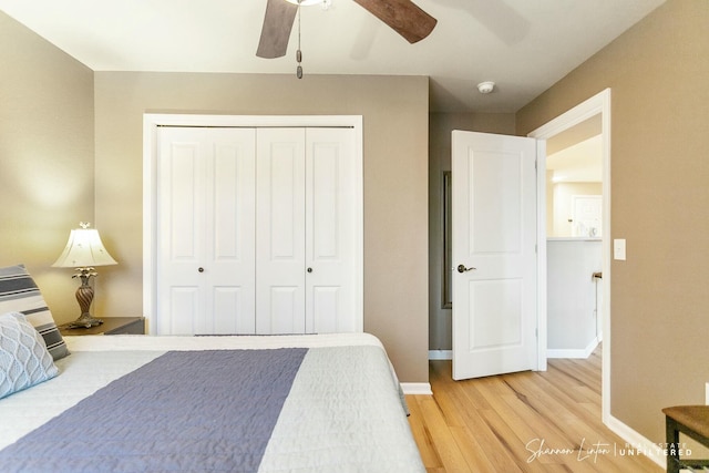 bedroom with light wood-type flooring, a closet, baseboards, and ceiling fan