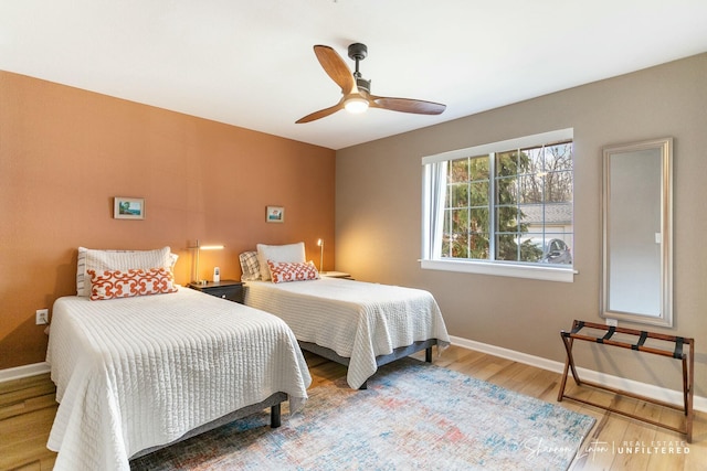 bedroom featuring a ceiling fan, wood finished floors, and baseboards