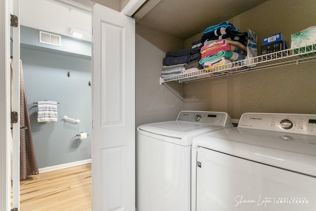 clothes washing area with visible vents, baseboards, laundry area, light wood-style floors, and independent washer and dryer