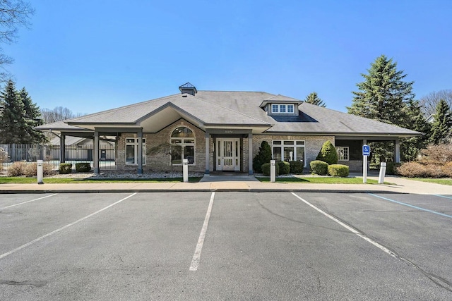 view of building exterior featuring uncovered parking and fence