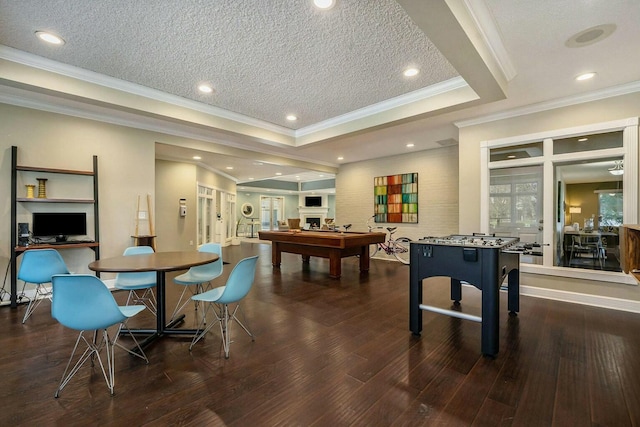 recreation room featuring dark wood finished floors, a tray ceiling, recessed lighting, and a textured ceiling