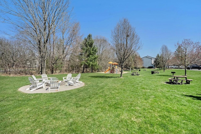 view of yard with a patio area, an outdoor fire pit, and a playground