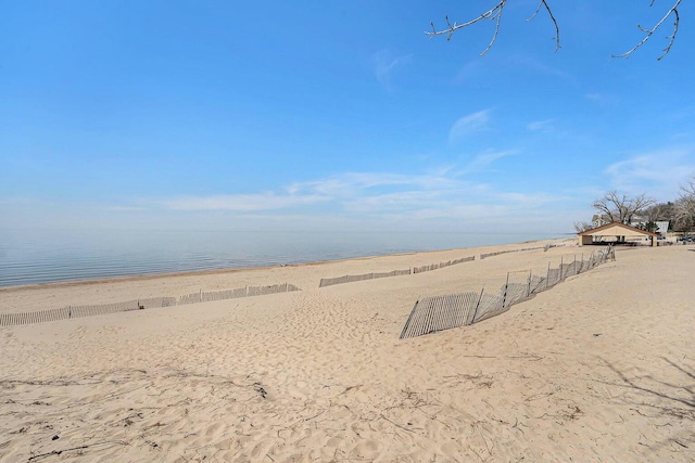 view of water feature with fence and a view of the beach