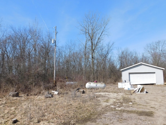 view of yard featuring a detached garage and an outdoor structure