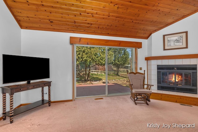 living area with visible vents, a tile fireplace, wood ceiling, and carpet