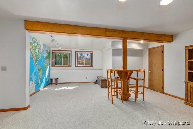 dining room with beam ceiling, carpet, and baseboards