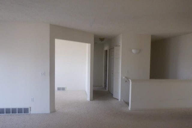 spare room with visible vents and light carpet