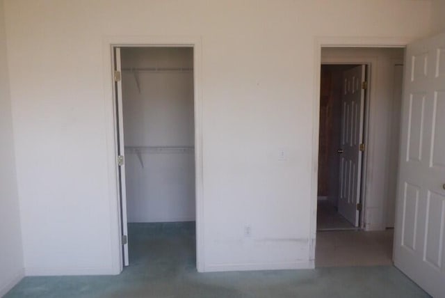 unfurnished bedroom featuring a walk in closet and a closet