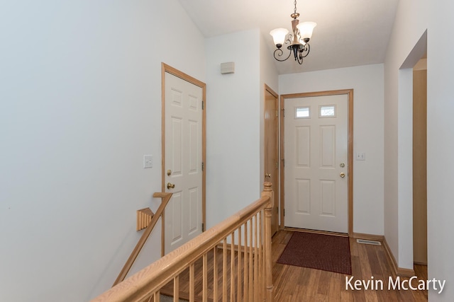 foyer with an inviting chandelier, wood finished floors, and baseboards