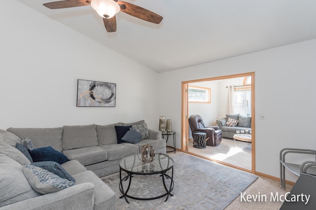 living area with baseboards, light carpet, ceiling fan, and vaulted ceiling