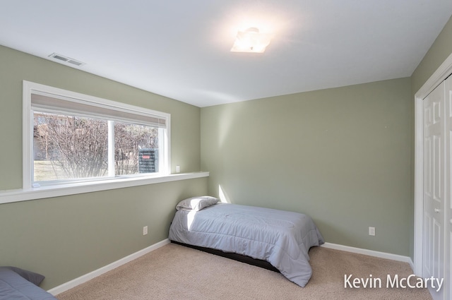 bedroom featuring a closet, visible vents, carpet flooring, and baseboards