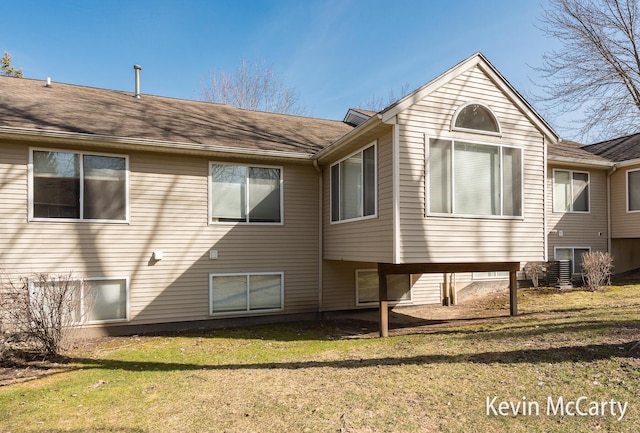 rear view of property featuring a lawn