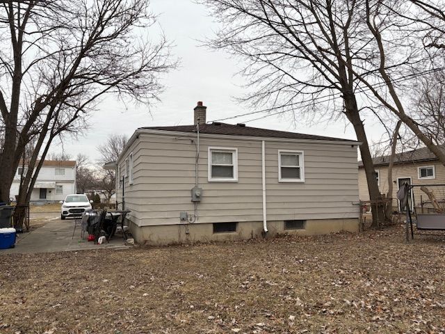 rear view of house featuring a chimney