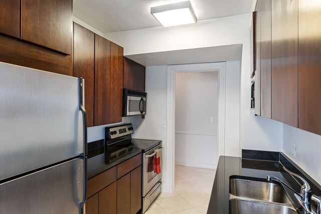 15 E Kirby St Unit 1104, Detroit, MI 48202 - kitchen featuring appliances with stainless steel finishes, a sink, dark countertops, and light tile patterned floors