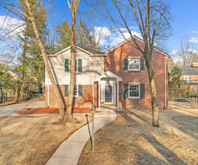 traditional-style house featuring brick siding and fence