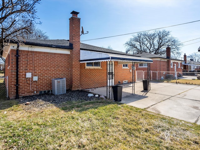 back of property with a patio, fence, central AC, a chimney, and brick siding