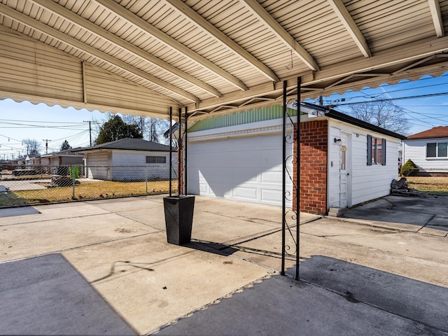 view of patio / terrace featuring a garage, driveway, and fence