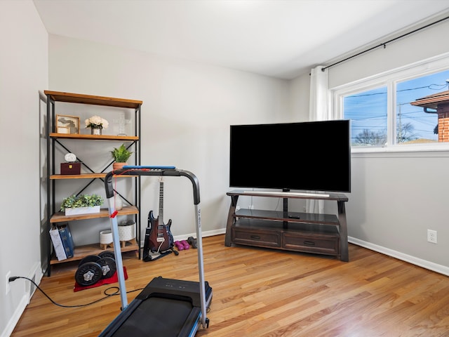 exercise area featuring wood finished floors and baseboards