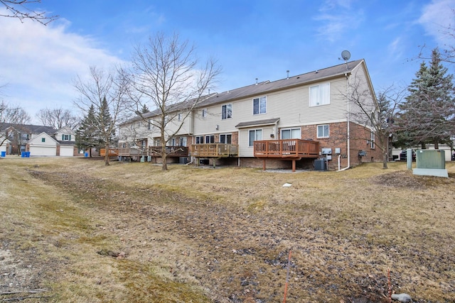 back of property featuring central air condition unit, brick siding, a residential view, and a wooden deck