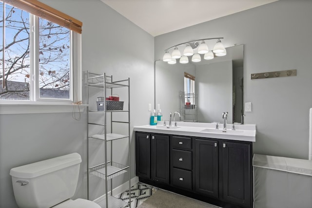 full bathroom with double vanity, toilet, and a sink