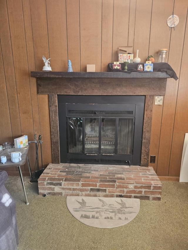 room details with carpet floors, a glass covered fireplace, and wood walls