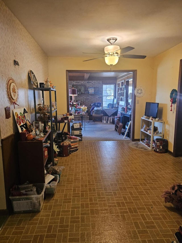 exercise area featuring brick patterned floor, wallpapered walls, and a ceiling fan