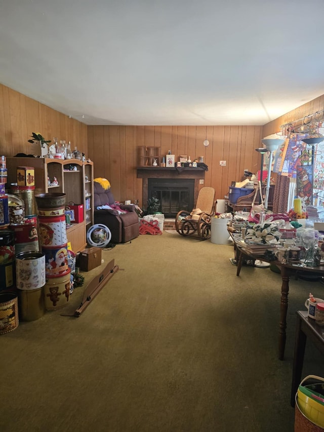 interior space with carpet floors, a glass covered fireplace, and wood walls