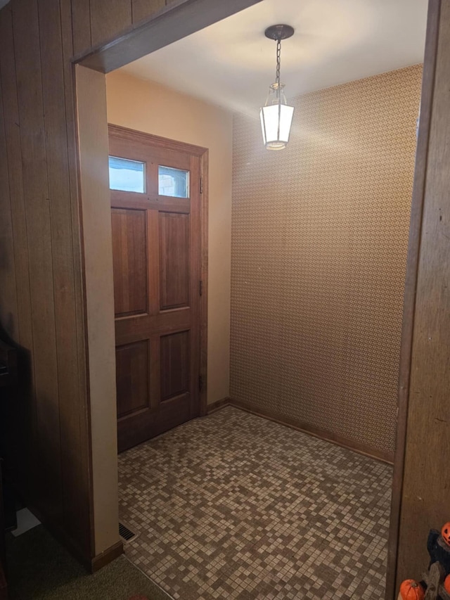 foyer featuring visible vents and dark carpet