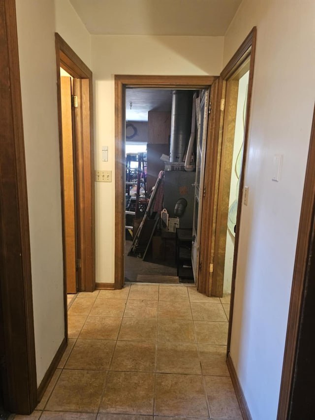 hall featuring tile patterned floors and baseboards