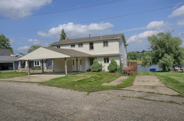 view of front facade with a front lawn, concrete driveway, and a carport