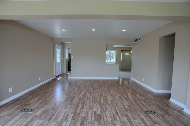 empty room with visible vents, recessed lighting, baseboards, and wood finished floors