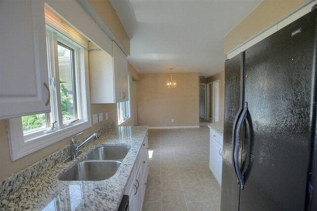 kitchen with a sink, white cabinetry, a healthy amount of sunlight, and freestanding refrigerator