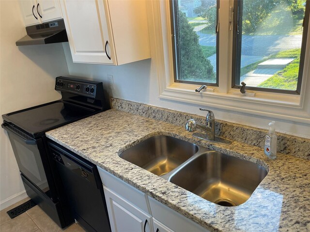 kitchen with black appliances, under cabinet range hood, light stone counters, white cabinetry, and a sink