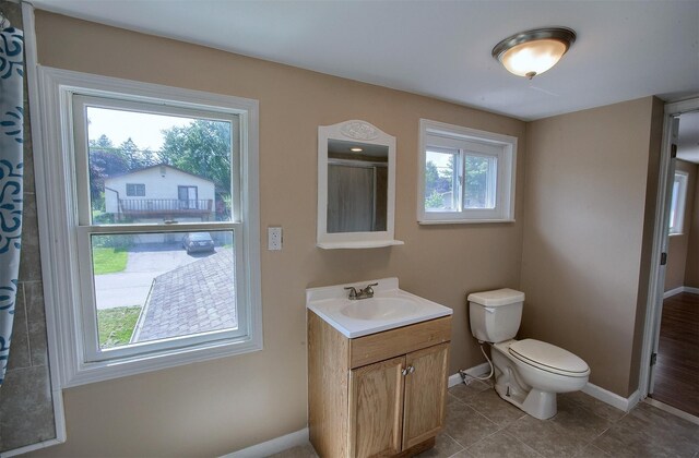 full bathroom featuring vanity, a shower with shower curtain, baseboards, tile patterned flooring, and toilet