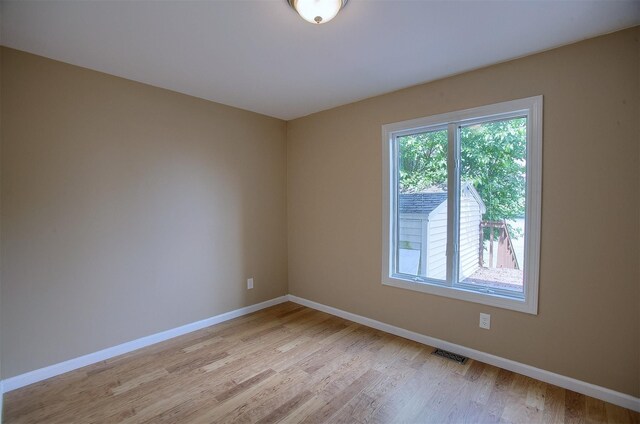 unfurnished room with light wood-style flooring, baseboards, and visible vents