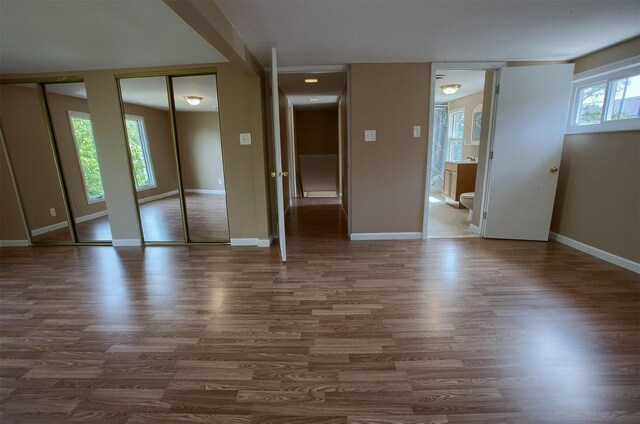 spare room featuring baseboards and wood finished floors