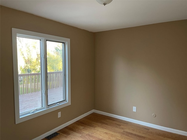 spare room with light wood-style floors, baseboards, and visible vents