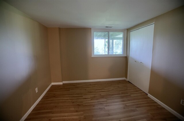 empty room with visible vents, baseboards, and wood finished floors