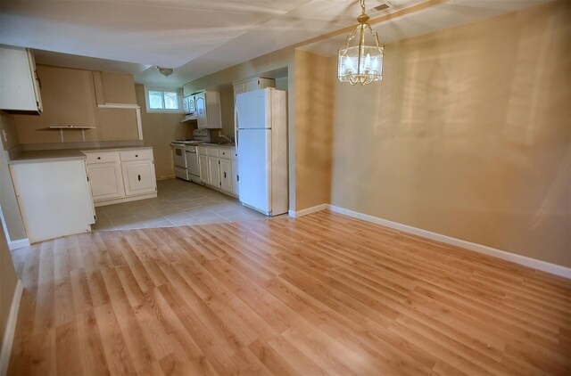 kitchen with light wood finished floors, freestanding refrigerator, baseboards, and range