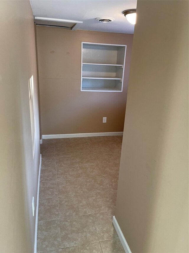 empty room with visible vents, baseboards, and tile patterned flooring